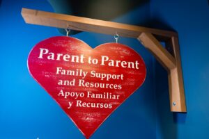 Heart Sign with the text: Parent to parent family support and resources. Apoyo Familiar y Recursos.